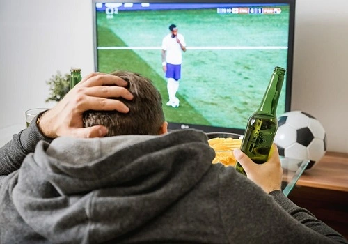 homem assiste na TV streaming de esportes